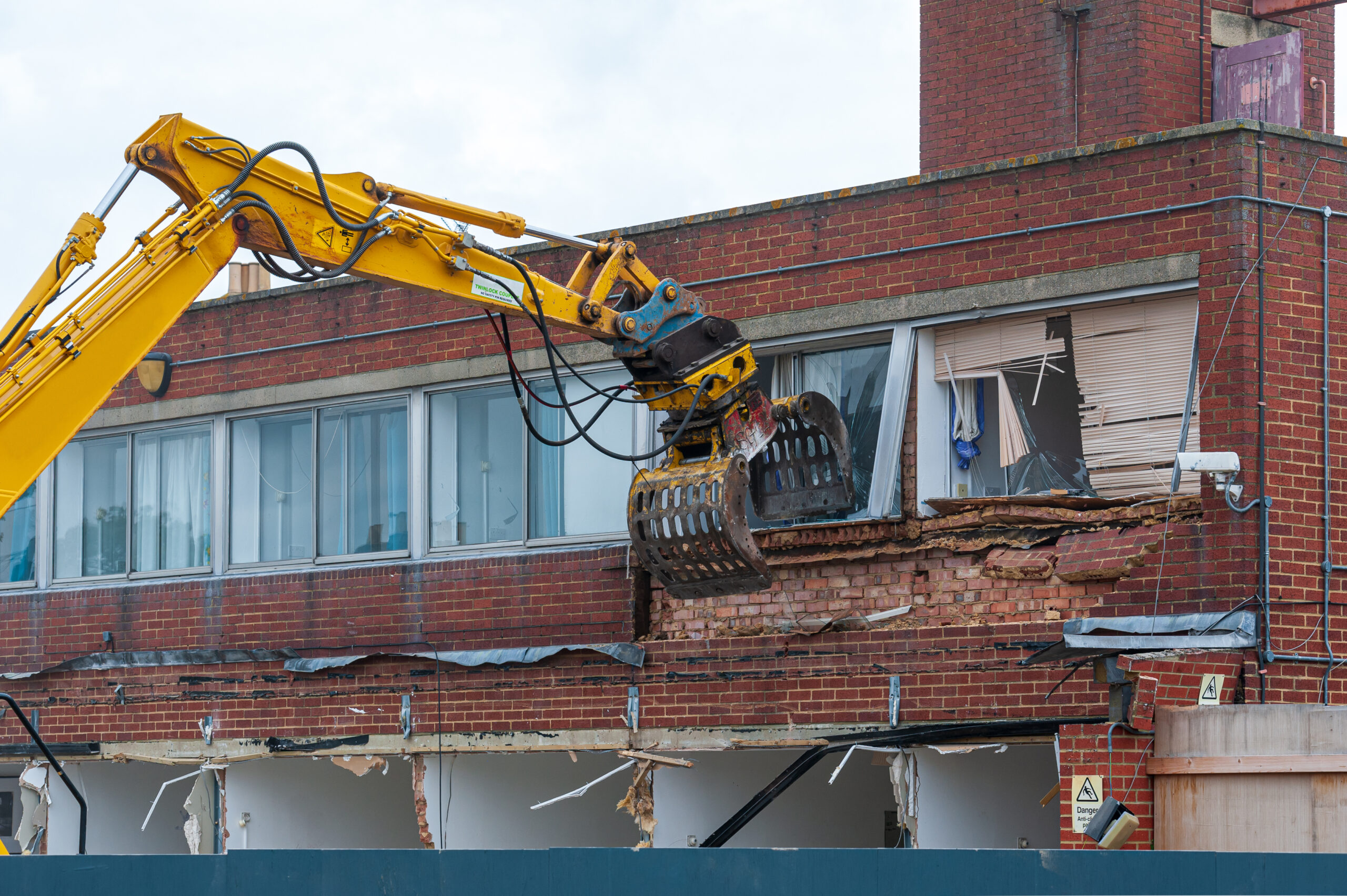 Demolition of an old building with a long reach machine hydraulic jaw. Regeneration of a space for new, modern building.